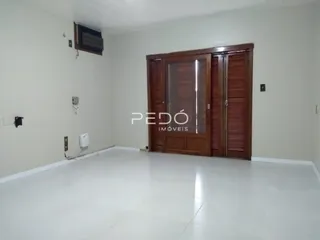 Ambiente interno de uma sala com paredes brancas e porta de madeira.