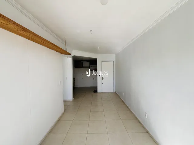 Corredor interno com piso de cerâmica claro e teto branco.
