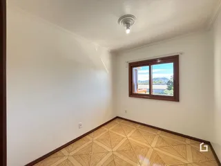 Interior de uma sala com piso de ladrilhos de madeira clara.