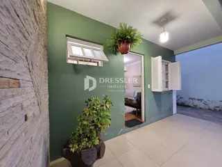 Ambiente interno de uma sala com parede verde e piso de cerâmica.