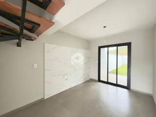 Ambiente interno com paredes brancas e piso de concreto em uma residência.