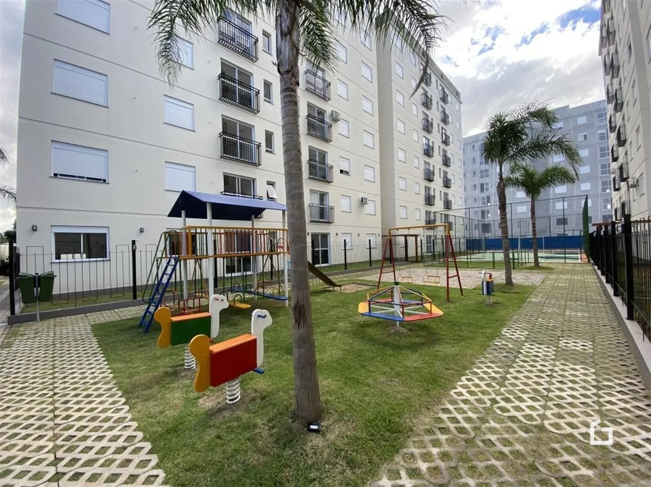 Vista da fachada de um prédio residencial com área de lazer externa.
