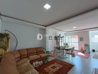 Sala de estar com sofá de couro marrom e tapete no interior da residência.