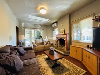 Sala de estar com sofá, piso de madeira e lareira.