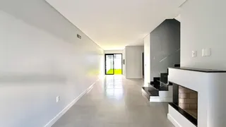 Corredor interno de uma residência com paredes brancas e piso claro.
