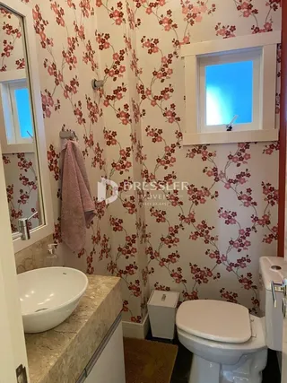 Foto de um banheiro com revestimento floral nas paredes.