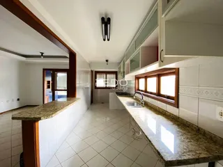 Vista interna de uma cozinha com bancada de granito e revestimento de cerâmica.
