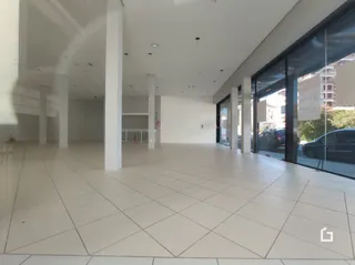 Espaço interno amplo com piso de cerâmica claro e paredes brancas.