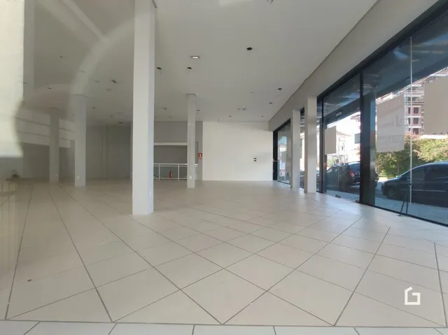 Espaço interno amplo com piso de cerâmica claro e paredes brancas.