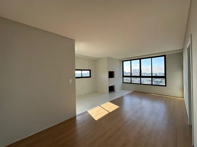 Vista interna de um ambiente com piso de madeira e paredes brancas.