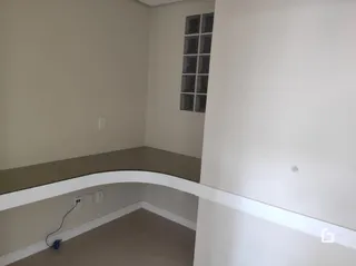 Vista interna de uma área com paredes claras e um teto branco.