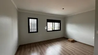 Sala de estar com piso de madeira e paredes cinzas.