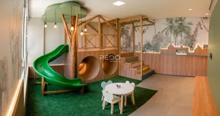 Interior de uma sala com decoração temática de madeira e verde.