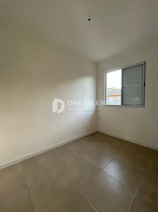 Foto de um ambiente interno com piso de cerâmica e paredes brancas.