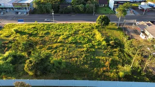 Vista aérea de um terreno com vegetação densa e grama no Brasil.