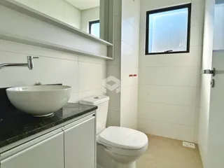 Foto de um banheiro moderno com pia e vaso sanitário.