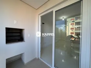 Hall de entrada com parede branca e porta de vidro que dá acesso a uma área externa.