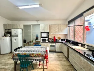 Cozinha e sala de jantar com armários de madeira e piso de madeira.