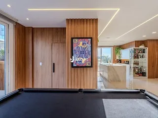Interior de uma sala com revestimento de madeira e acabamentos modernos.