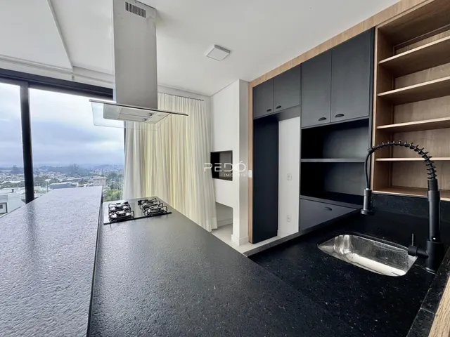 Cozinha moderna com grandes janelas oferecendo uma vista panorâmica.
