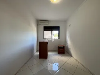 Corredor interno de um imóvel em Lajeado, Brasil, com piso de cerâmica e paredes brancas.