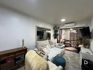 Sala de estar com sofá e cama em ambiente claro.