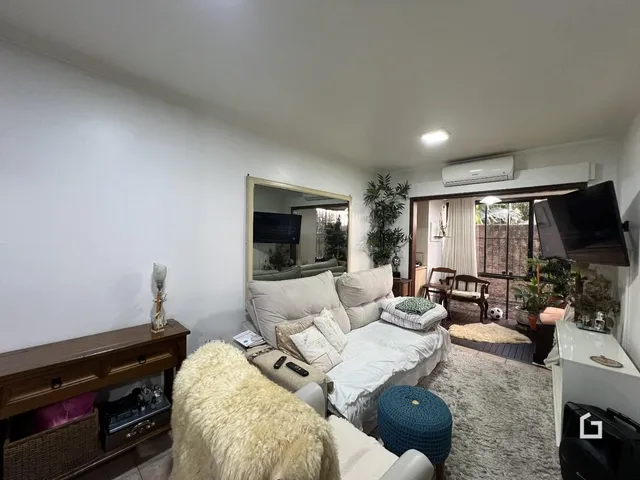 Sala de estar com sofá e cama em ambiente claro.