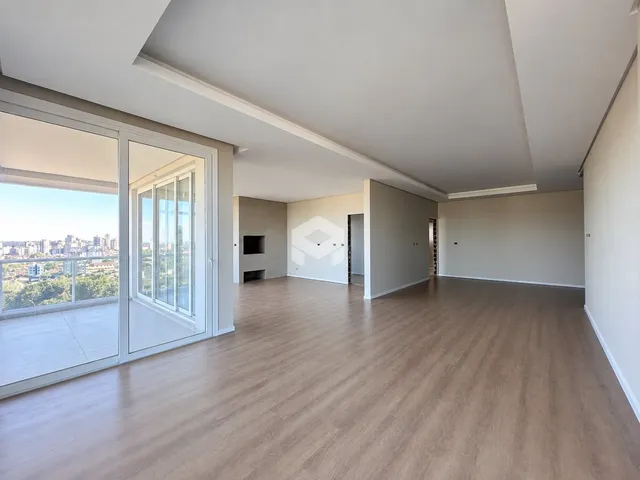 Ambiente interno de um apartamento moderno com grande área e vista para a cidade.