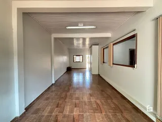 Corredor interno com piso de cerâmica em uma residência.