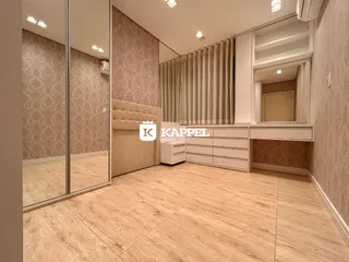 Foto de um quarto com piso de madeira clara e cabeceira estofada.