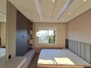 Quarto com cama de casal e decoração moderna em ambiente claro.