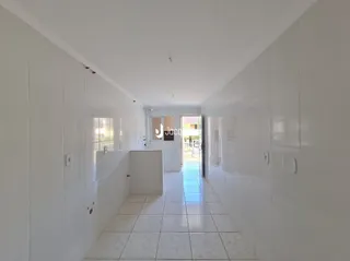 Corredor interno de uma residência com paredes brancas.