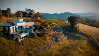 Vista panorâmica de uma propriedade rural com colinas e vegetação seca.