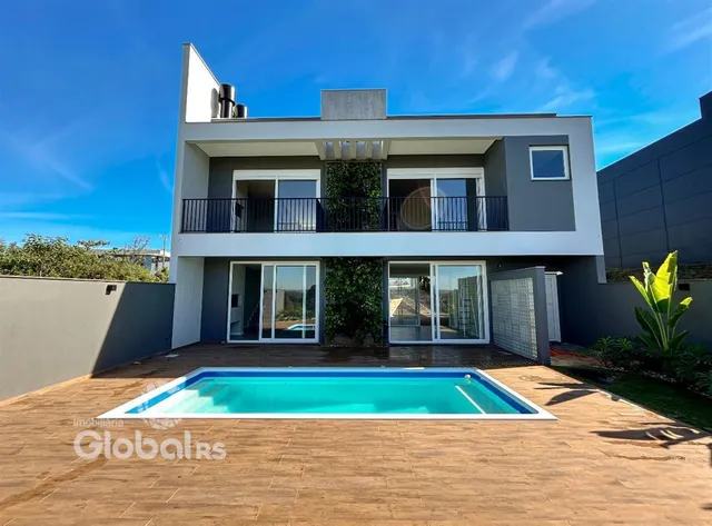 Fachada de uma casa moderna com piscina no quintal.