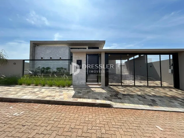 Fachada moderna de uma residência em Lajeado, Brasil, com muro e paisagismo.