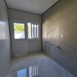 Hall de entrada com porta de vidro e iluminação natural.