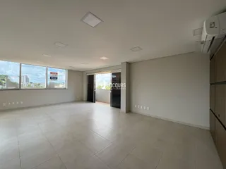 Sala ampla com piso de cerâmica e vista da cidade.