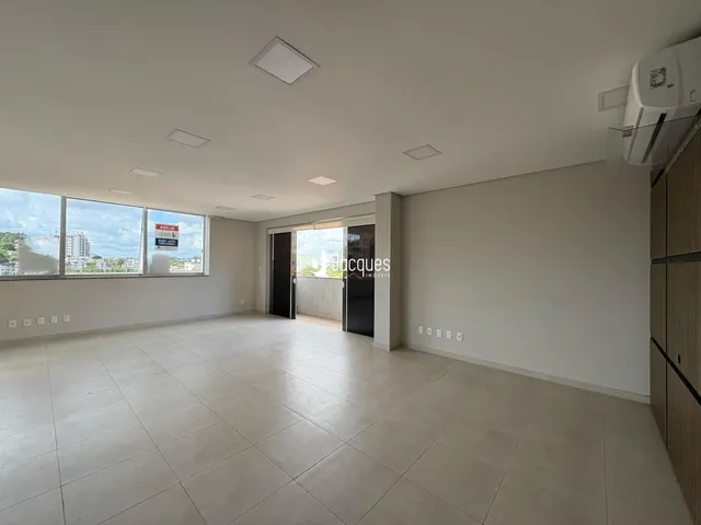 Sala ampla com piso de cerâmica e vista da cidade.