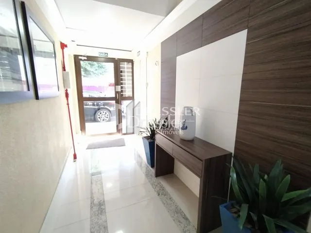 Corredor interno de uma residência com piso claro e paredes brancas.