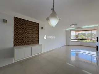 Ambiente interno de uma sala ampla com piso claro e parede decorada.