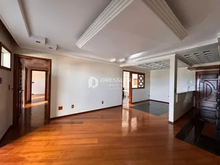 Sala ampla com piso de madeira polida.