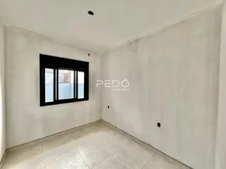 Vista interna de um ambiente com paredes brancas e piso de cerâmica.