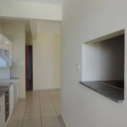 Hall de entrada com piso de cerâmica claro e paredes brancas.