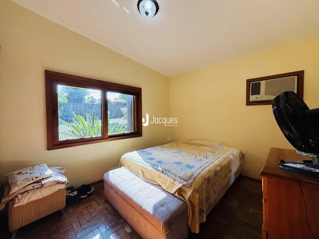 Quarto com janela e piso de madeira em Lajeado.