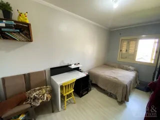 Quarto interno com cama e escrivaninha em um ambiente claro.