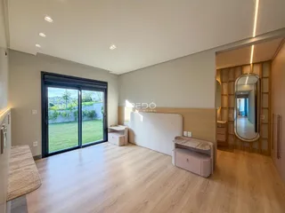 Sala de estar com piso de madeira e porta de vidro que dá para o jardim.