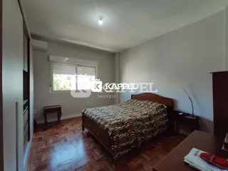 Quarto com cama de casal e piso de madeira.