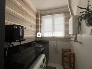 Foto de uma cozinha com bancada escura e janela com persianas.