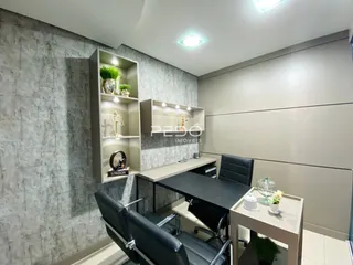 Ambiente moderno com mesa de trabalho e estantes em um imóvel.