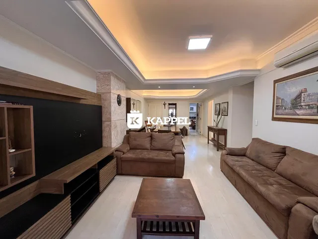 Sala de estar com sofá e móveis de madeira em um ambiente claro.